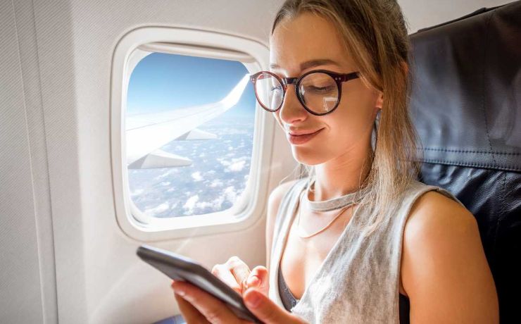 Donna con cellulare in aereo