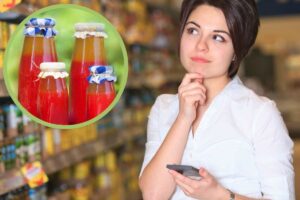 donna al supermercato e bottiglie di passata di pomodoro