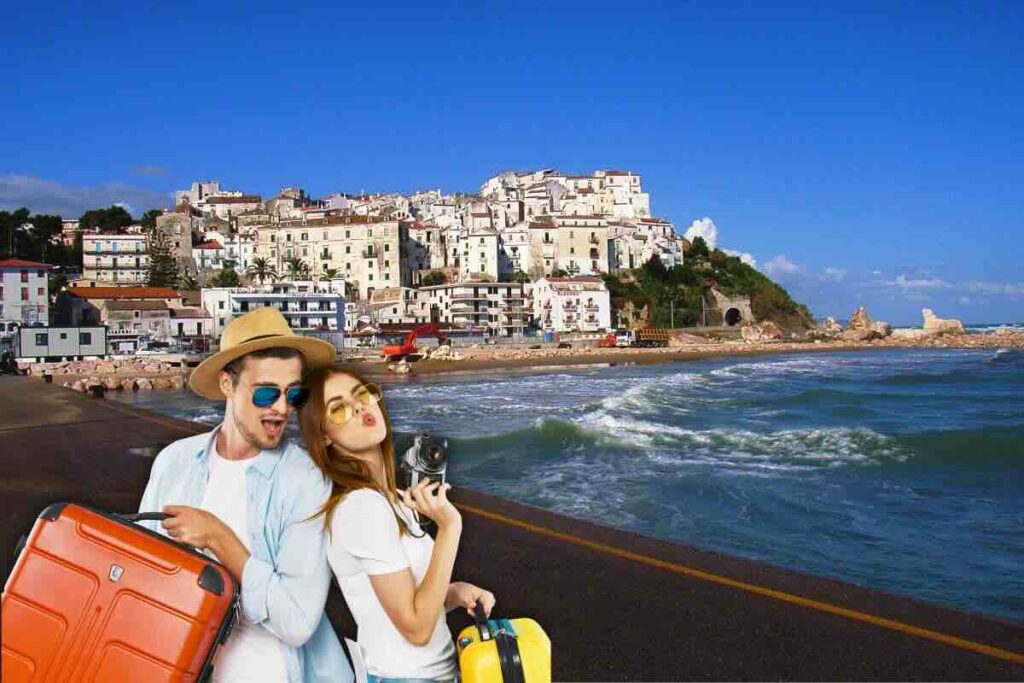 Ragazzo e ragazza con valigie e sullo sfondo città di mare