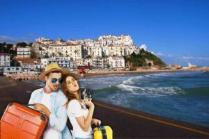 Ragazzo e ragazza con valigie e sullo sfondo città di mare