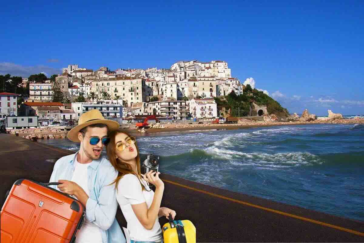 Ragazzo e ragazza con valigie e sullo sfondo città di mare