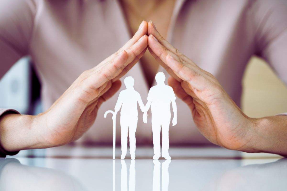 i ritagli di due persone e delle mani a proteggerli