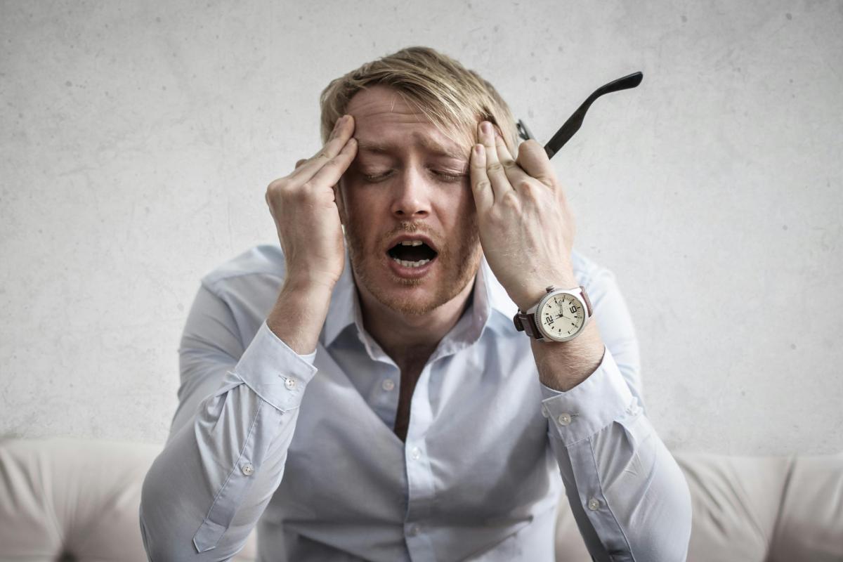 Uomo disperato con le mani sulle tempie